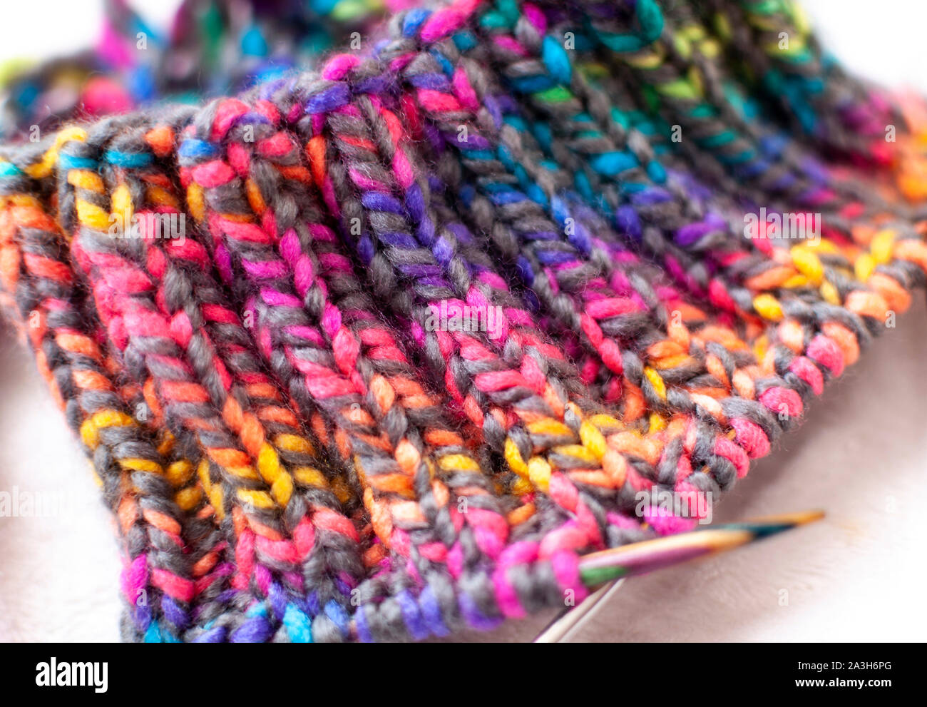 Disegno di lavorazione a maglia, tessitura di filati colorati e gli aghi di close-up. Foto Stock