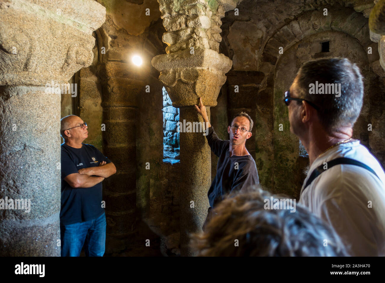 I turisti che visitano la romanica del XII secolo cripta sotto la St Vincent la cappella presso il Château de Tiffauges, il castello medievale, della Vandea, Francia Foto Stock