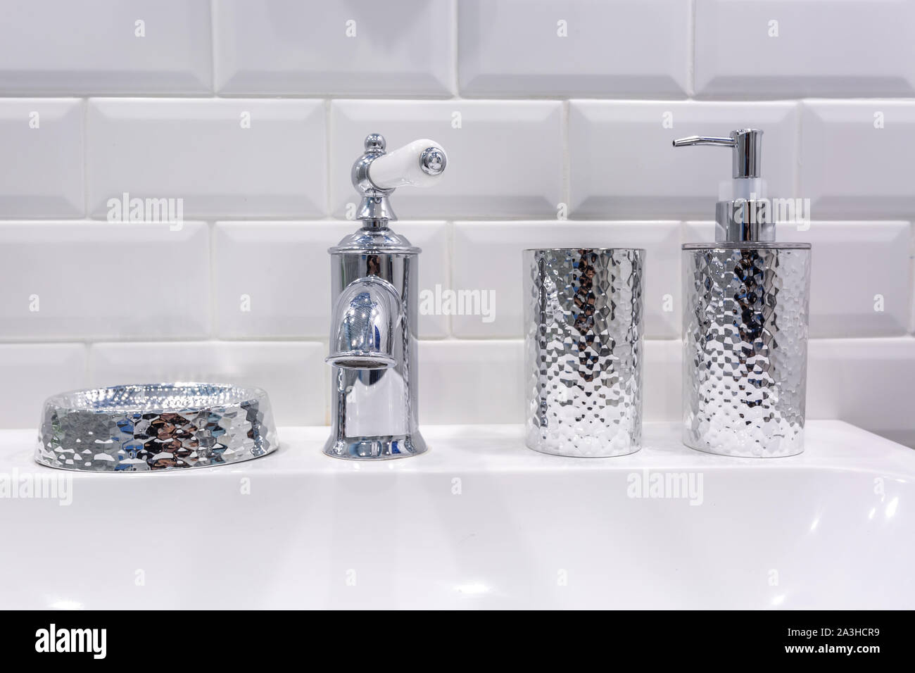 Il sapone e lo shampoo dispenser vicino ceramica rubinetto acqua lavandino con rubinetto in costosi loft bagno Foto Stock