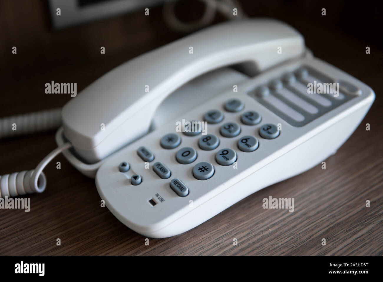 Vintage bianco telefono con battoms grigio su un tavolo marrone in hotel. Foto Stock