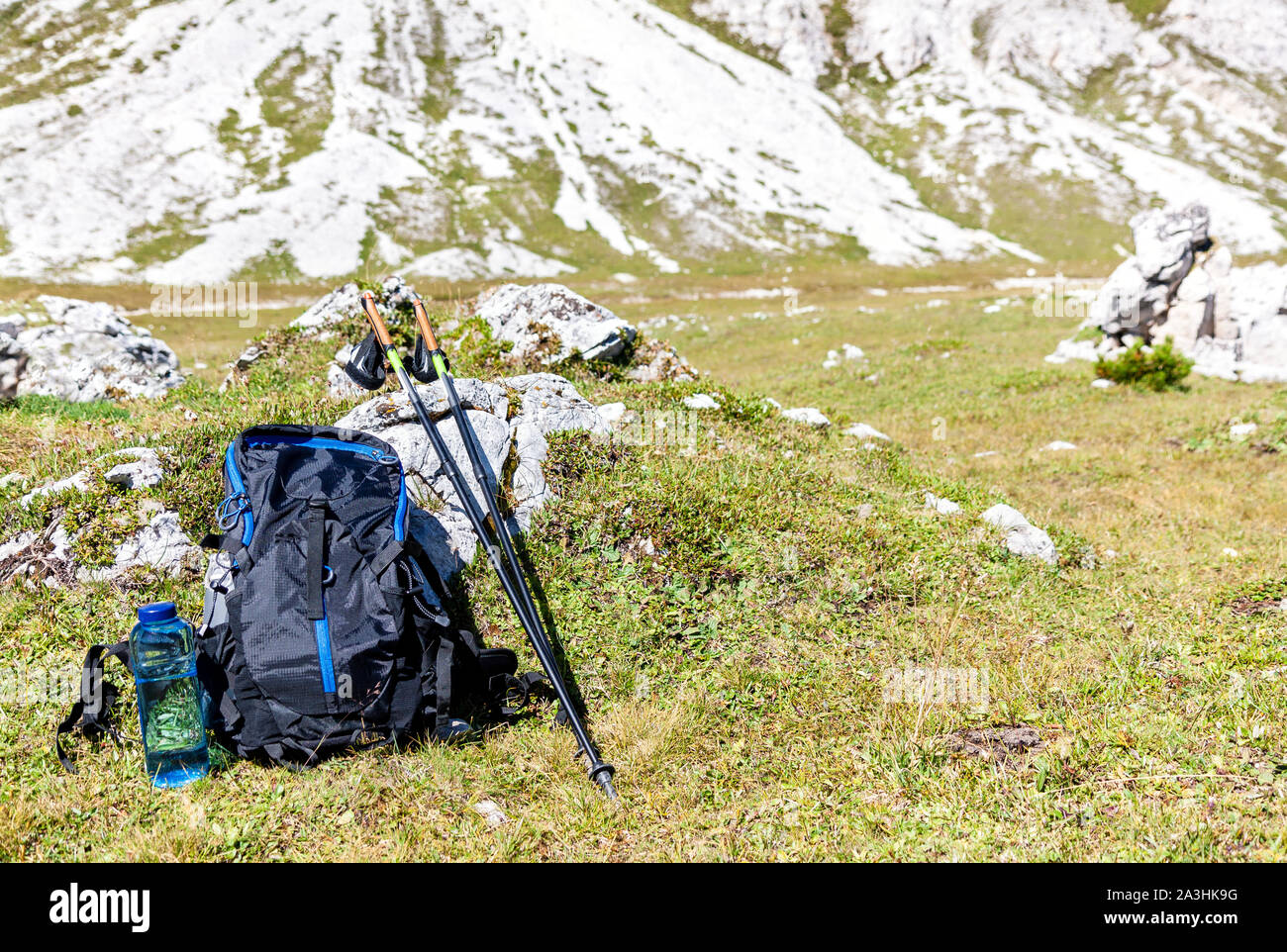 Attrezzatura per le escursioni in montagna in estate con copia spazio, turismo zaino e bastoncini nordic walking nel paesaggio di montagna Foto Stock