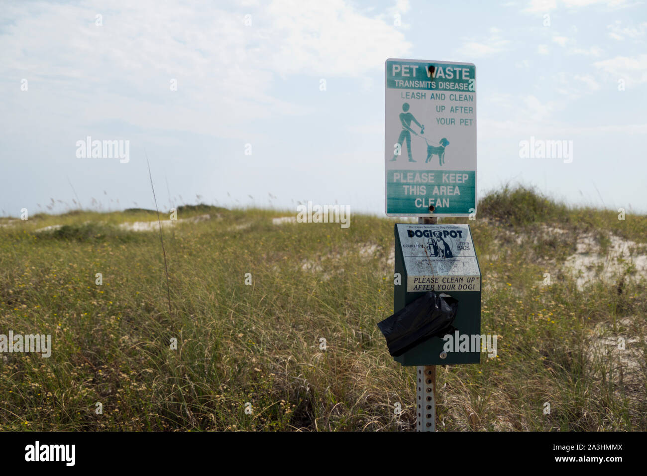 Sacchetto di plastica dispenser e il segno che ricorda il proprietario di pet di pulizia dopo i loro animali a Rosamond Johnson, Jr. Parco Nazionale nei pressi di Pensacola, Florida, Foto Stock