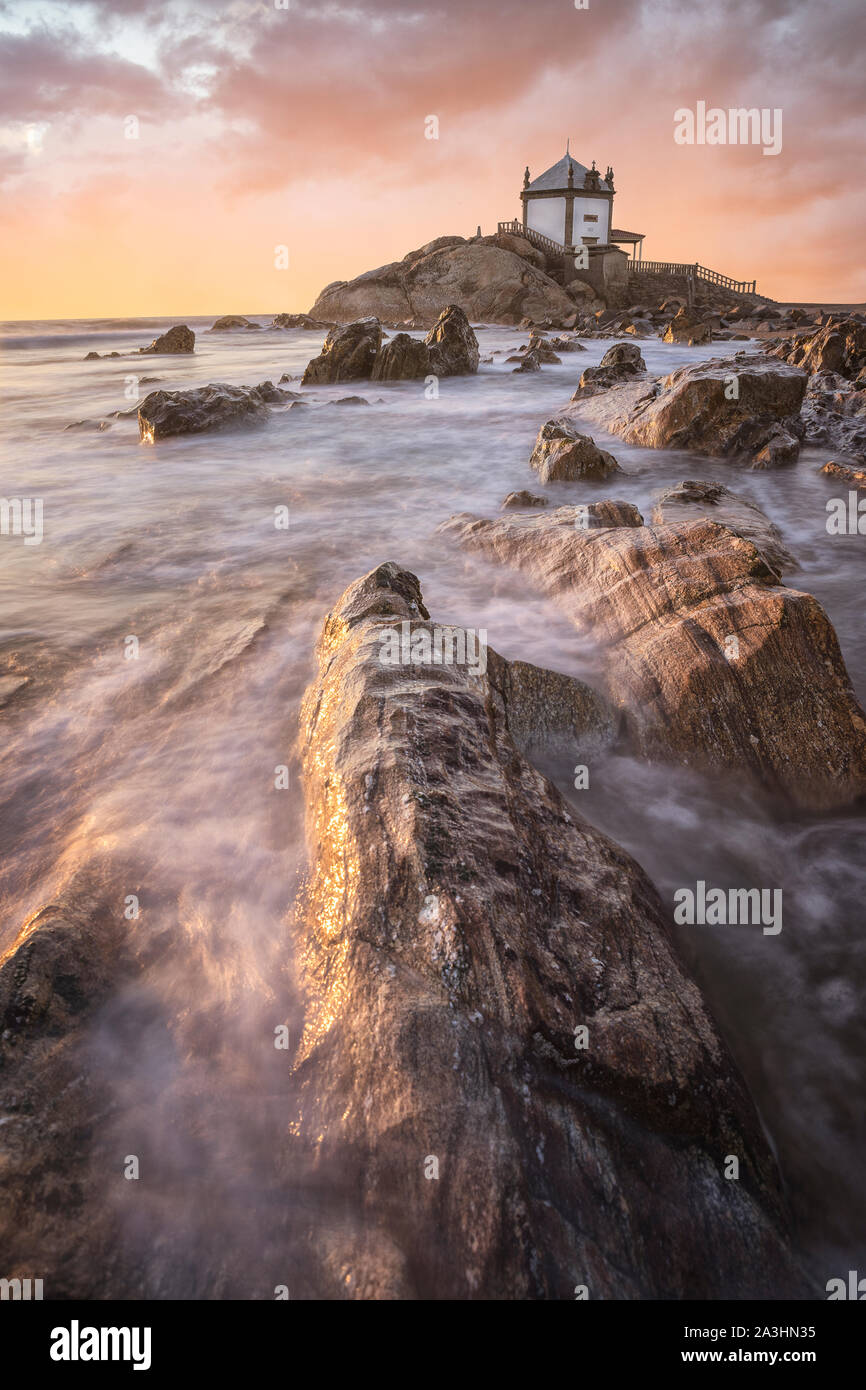 "Capela do Senhor da Pedra" al tramonto oltre oceano Atlantico Foto Stock