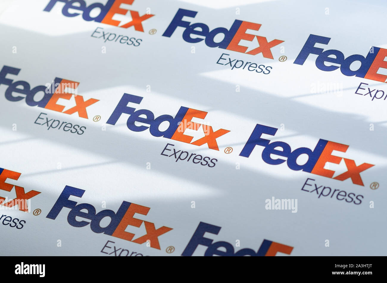 Più FedEX logo su una grande tela con la luce naturale del sole che cade su di esso. La profondità di campo è utilizzato. Foto Stock