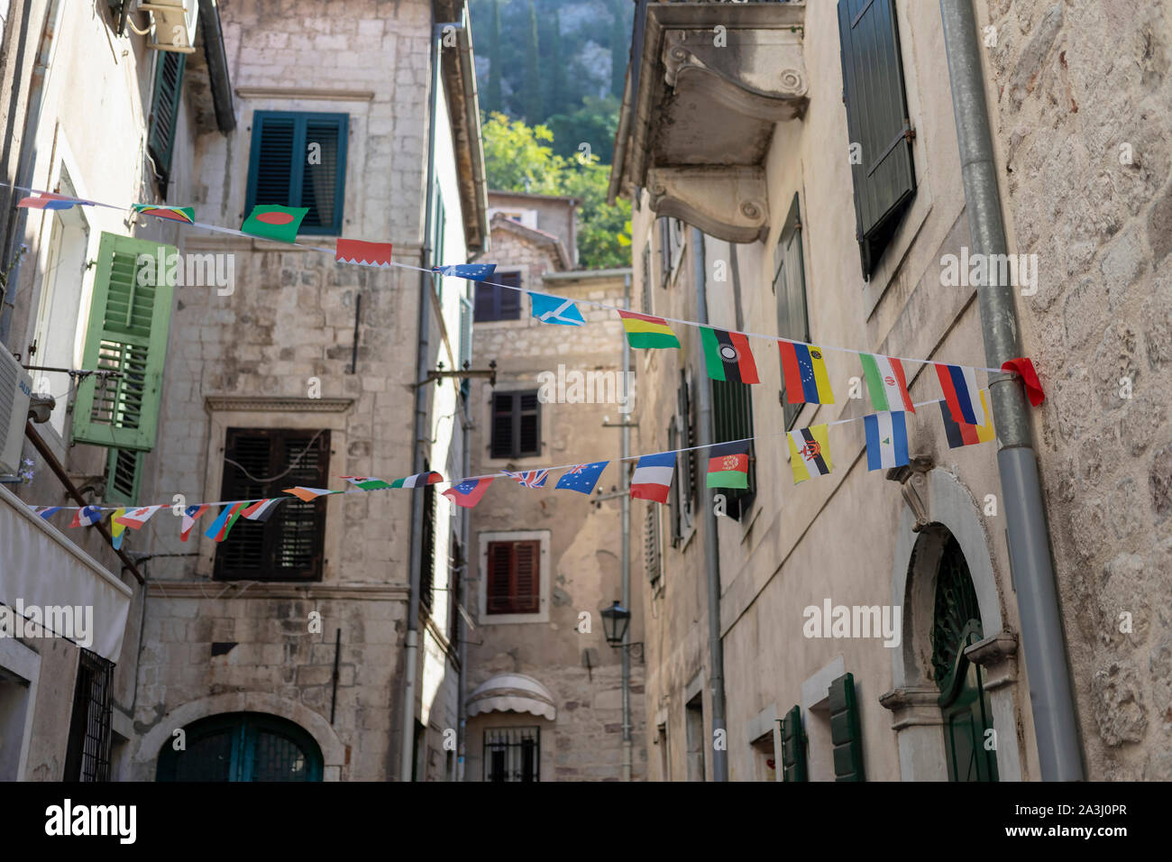 Montenegro - bandiere dei vari membri decorare una stretta strada di Cattaro Città Vecchia Foto Stock
