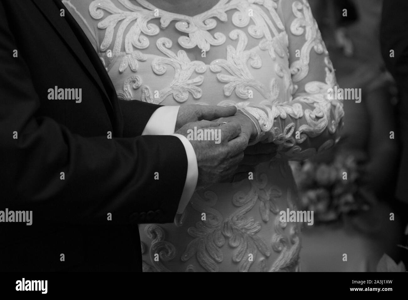 Sposa e sposi le mani su di loro giorno delle nozze, close up della sposa e sposi le mani al loro matrimonio il loro giorno delle nozze in Worcestershire Inghilterra, Regno Unito Foto Stock