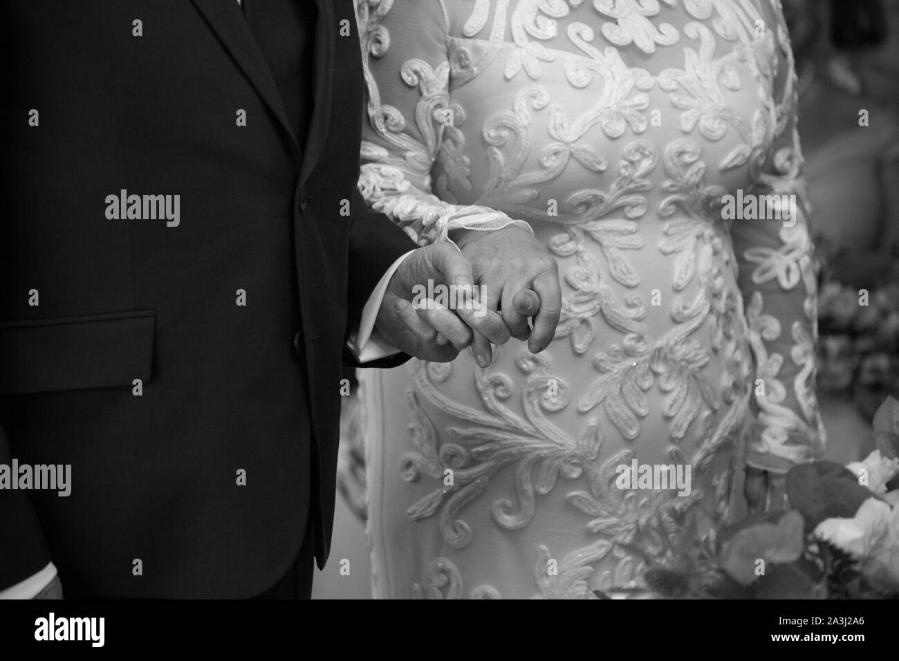 Close up della sposa e lo sposo tenendo le mani mentre dicendo i loro voti e scambiare gli anelli sul loro giorno di nozze in Worcestershire, Inghilterra Foto Stock