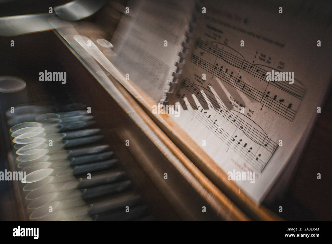 Sole di mattina brilla su tasti di pianoforte con la musica del foglio di Sfocatura creativa Foto Stock