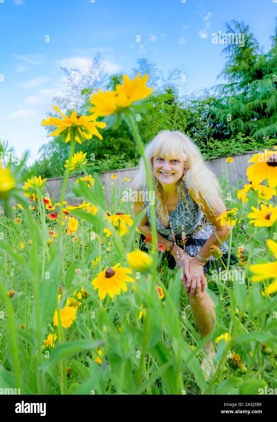 La donna nel suo cortile giardino di fiori di campo. Foto Stock