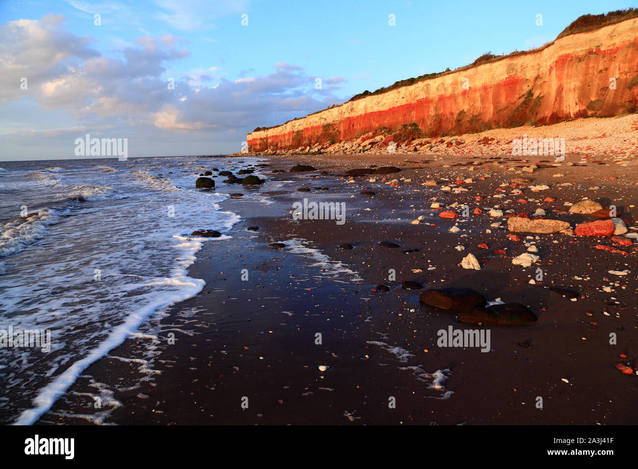 Old Hunstanton, scogliere a strisce, spiaggia, il lavaggio, del Mare del Nord, Norfolk, Inghilterra, Regno Unito, gesso, carstone Foto Stock