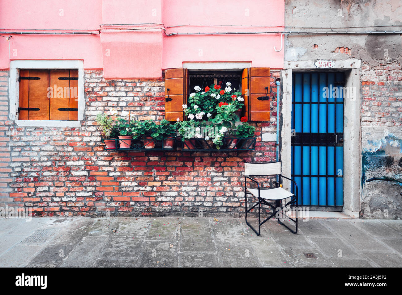 Vecchia strada italiana con fiori in vaso sulla parete rustico sfondo. Sfondo di viaggio Foto Stock