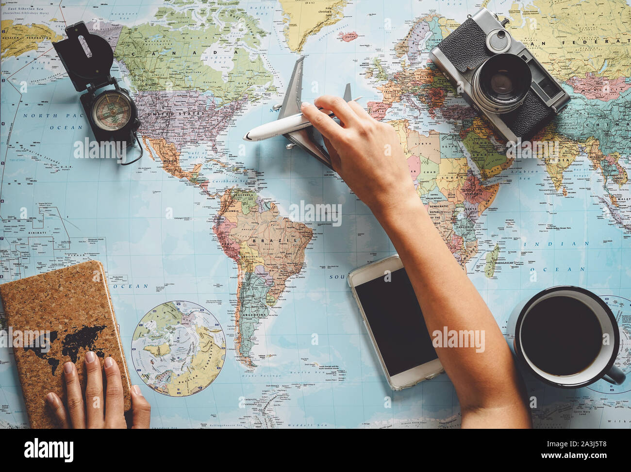 Vista superiore della giovane donna a pianificare il suo vacanza utilizzando la mappa del mondo - consulente di viaggio alla ricerca della prossima destinazione di viaggio Foto Stock