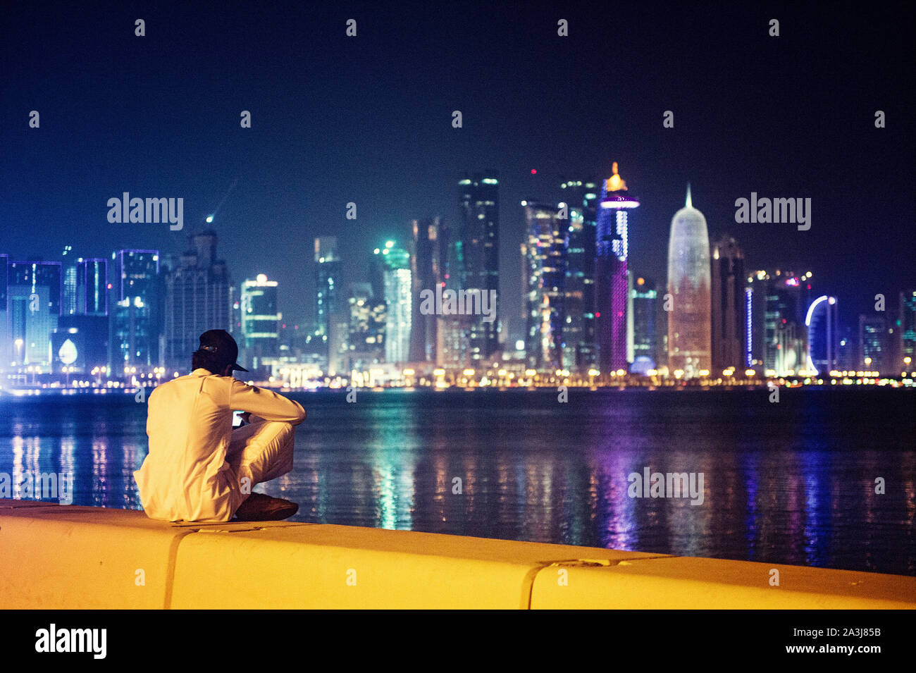 Lo skyline di Doha si riflette sull'acqua di notte Foto Stock