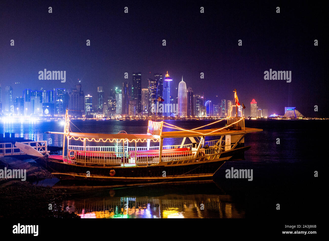 Lo skyline di Doha si riflette sull'acqua di notte Foto Stock