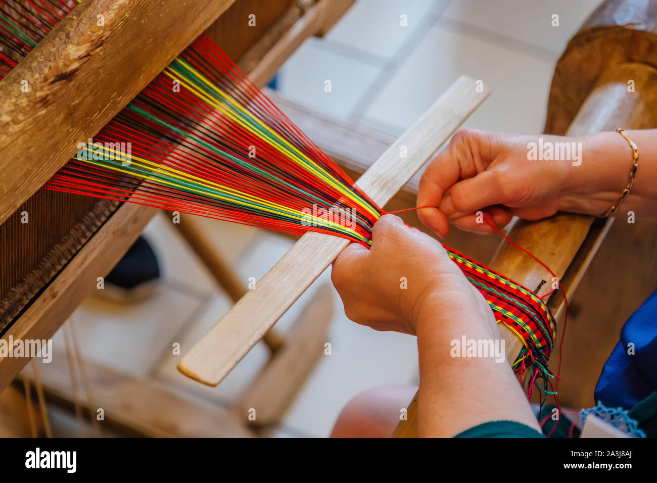 La donna lavora con mano tradizionale telaio di tessitura. Foto Stock