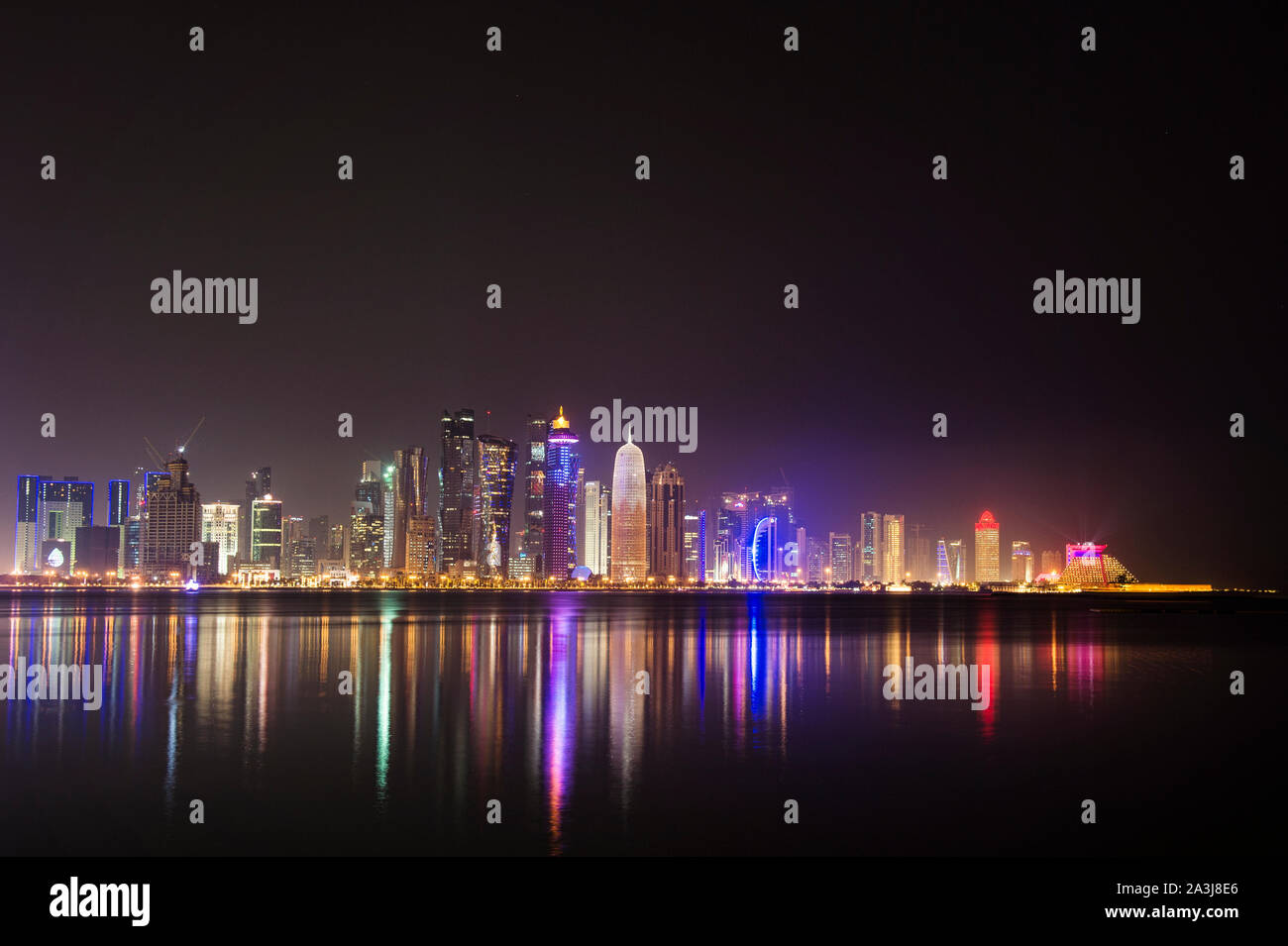 Lo skyline di Doha si riflette sull'acqua di notte Foto Stock