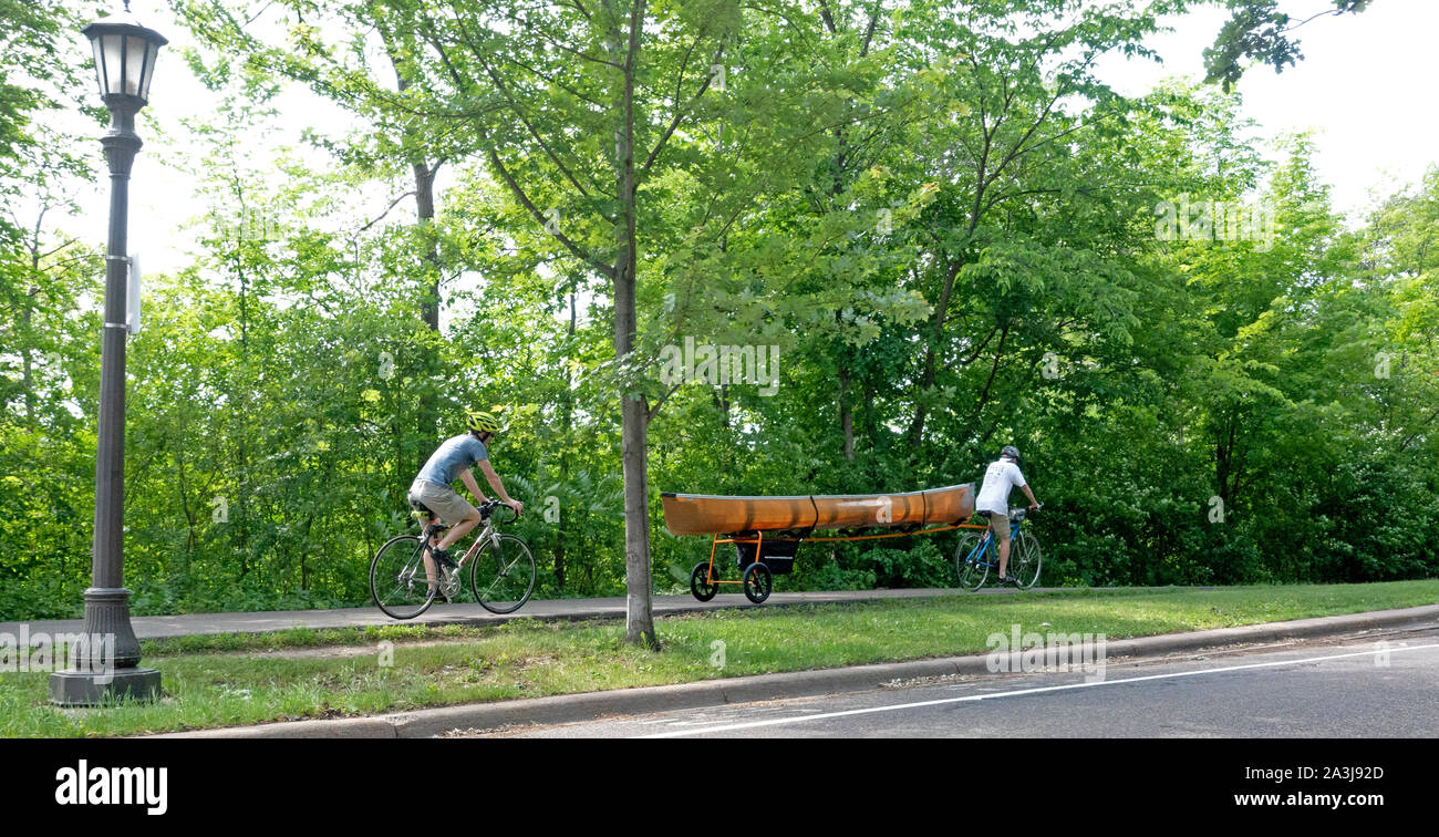 Bicyclers tirando una canoa su un rimorchio bici lungo il fiume Mississippi Boulevard trail. St Paul Minnesota MN USA Foto Stock