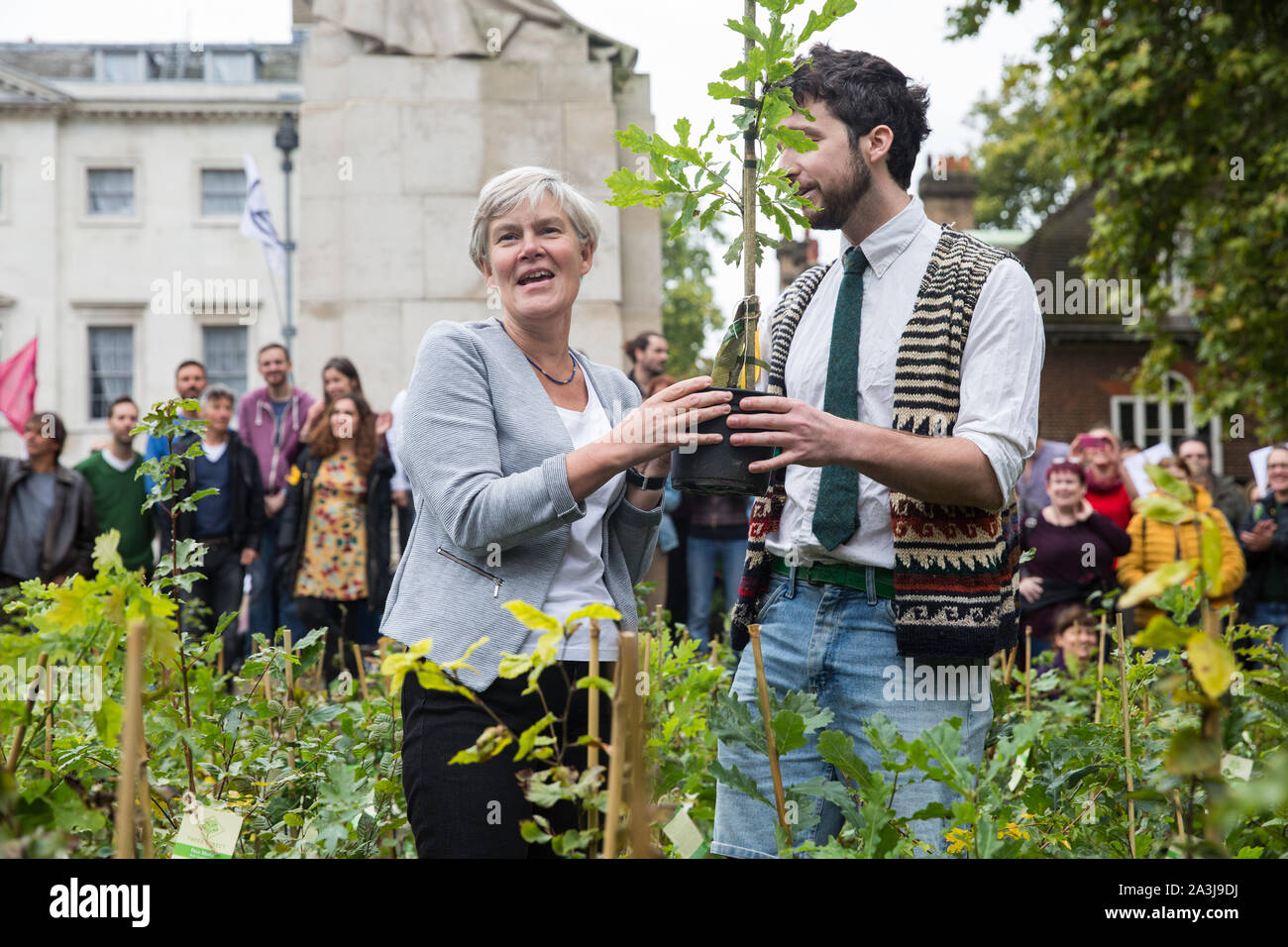 Londra, Regno Unito. 8 Ottobre, 2019. Kate Green, manodopera MP per Stretford e Urmston, riceve un albero dalla ribellione di estinzione attivisti del clima in Palazzo Vecchio Cantiere sulla seconda giornata internazionale di proteste di ribellione. Gli attivisti ha creato una neonata foresta di vasi di alberi nativi al di fuori del Parlamento come parte di un'iniziativa denominata rimboschire Massa e poi sono stati presentati ai parlamentari per chiedere al governo di impianto di miliardi di alberi in tutto il Regno Unito e il supporto la piantagione di trilioni di più in tutto il mondo. Credito: Mark Kerrison/Alamy Live News Foto Stock