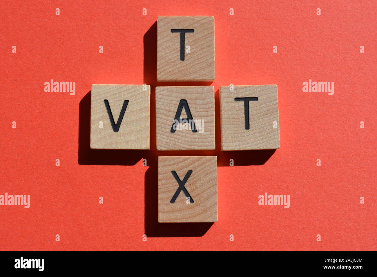 Imposta e l'acronimo IVA Imposta sul valore aggiunto in 3d alfabeto di legno lettere su un brillante sfondo arancione Foto Stock