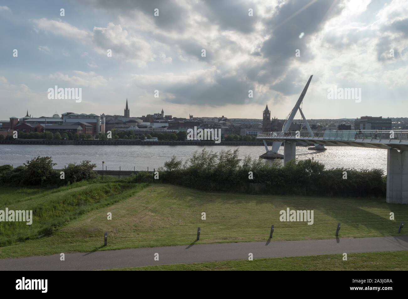 Il ponte di pace oltre il Fiume Foyle con Derry/Londonderry skyline in background Foto Stock