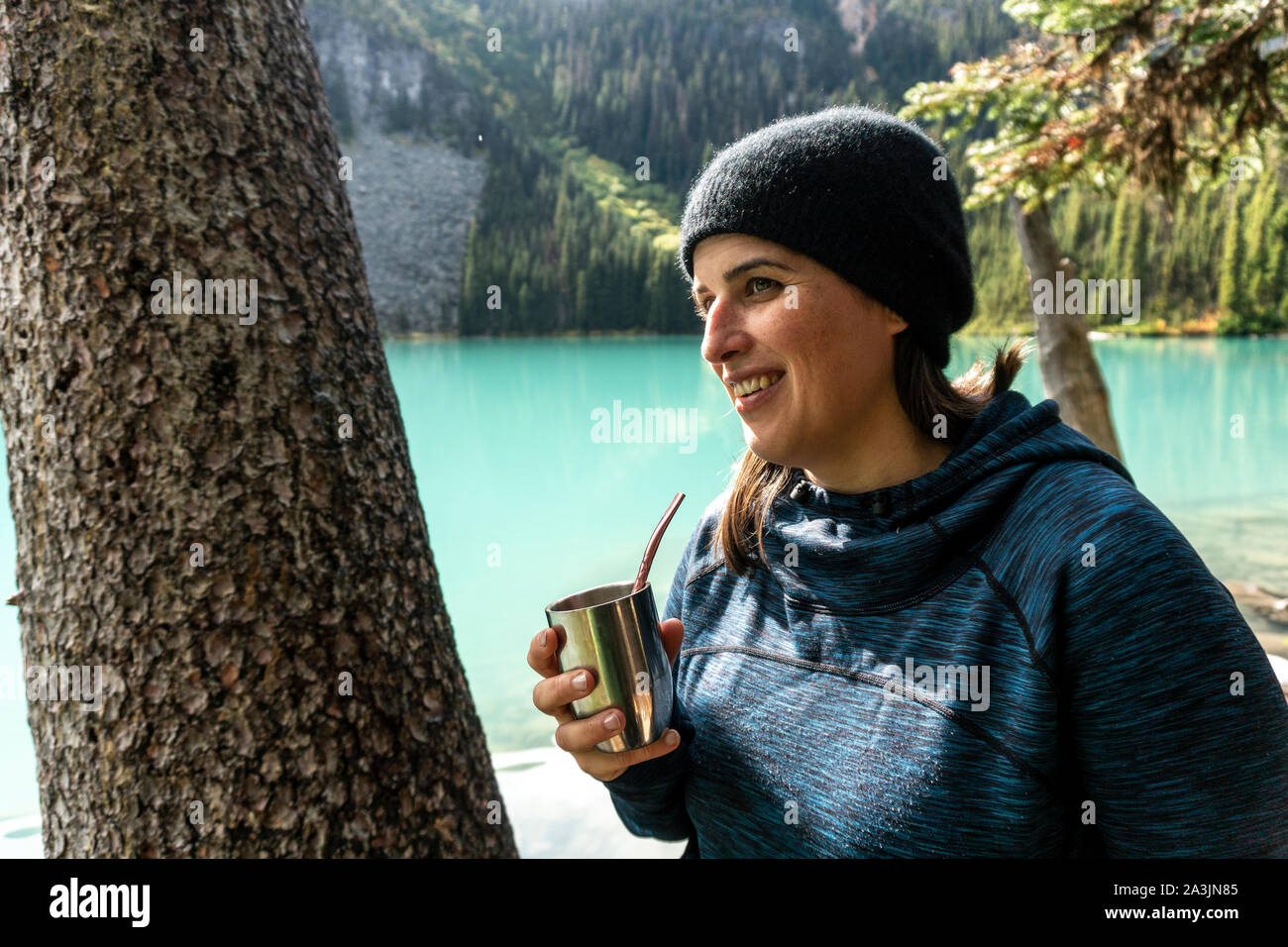 Mezza lunghezza shot di donne gustando il tè in una giornata di sole a Joffre laghi. Foto Stock