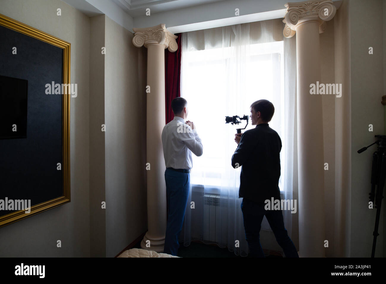 Novosibirsk, Russia - 15.06.2019: un videografo operatore spara un video del matrimonio durante la raccolta e la preparazione di lo sposo per un incontro con il b Foto Stock