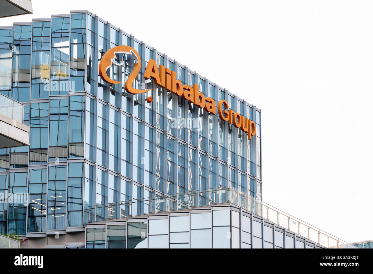 Multinazionale cinese e-commerce, retail, Internet e il conglomerato di tecnologia società holding del Gruppo Alibaba logo che si vede sulla cima di un grattacielo. Foto Stock