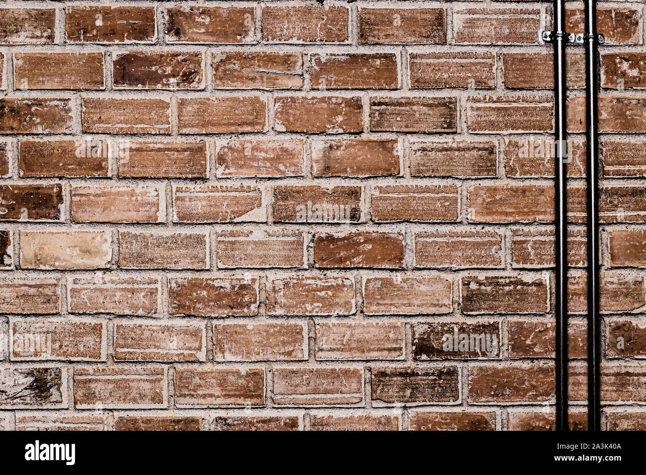 Muro di mattoni con cavo e tubo in acciaio vecchio texture grunge background industriale Foto Stock