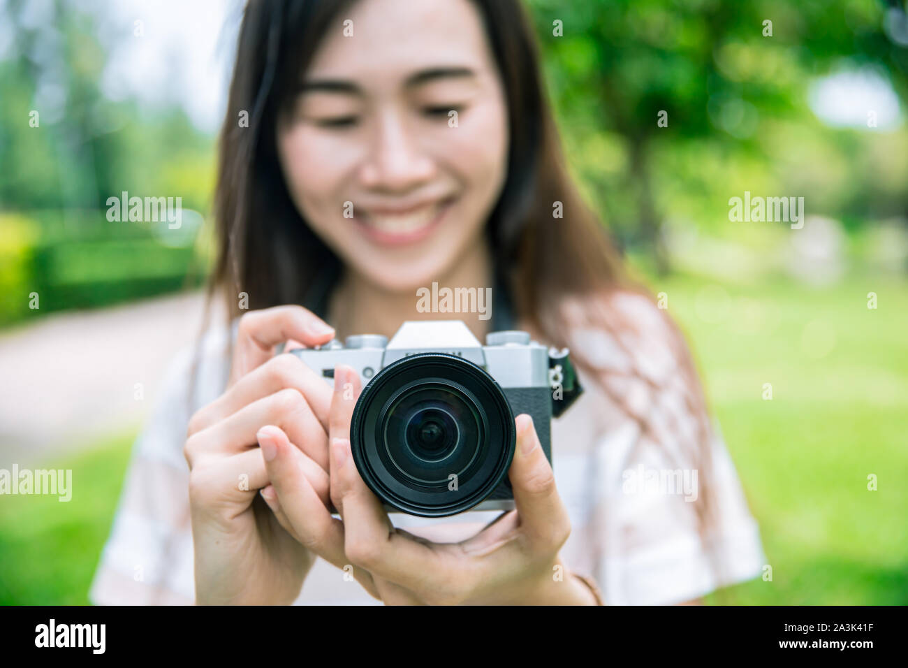Donne fotografo tenere la fotocamera scattare una foto outdoor hobby sorriso. Foto Stock