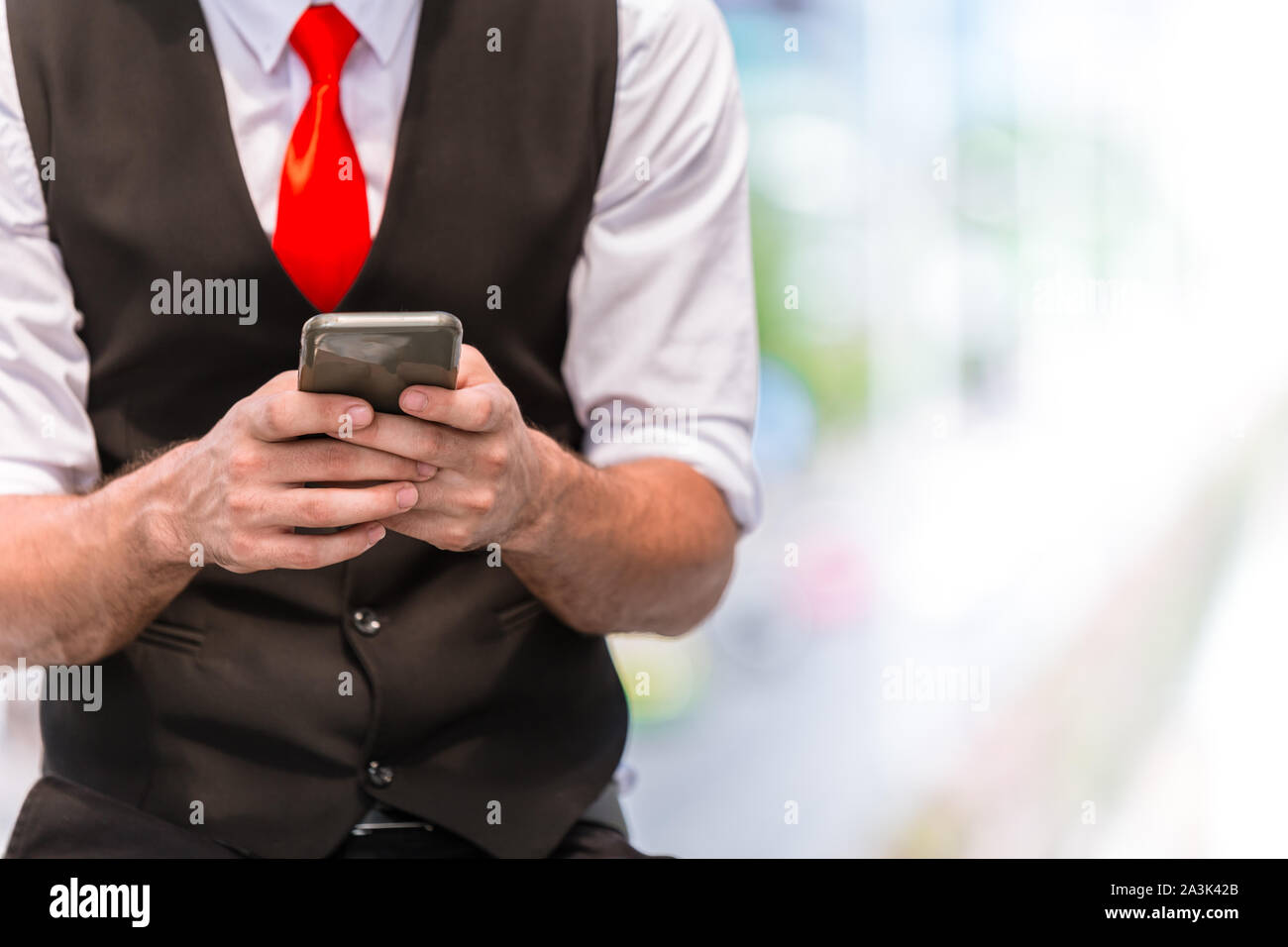Primo piano fashion elegante business man digitando smartphone indossa cravatta rossa con spazio per il testo Foto Stock