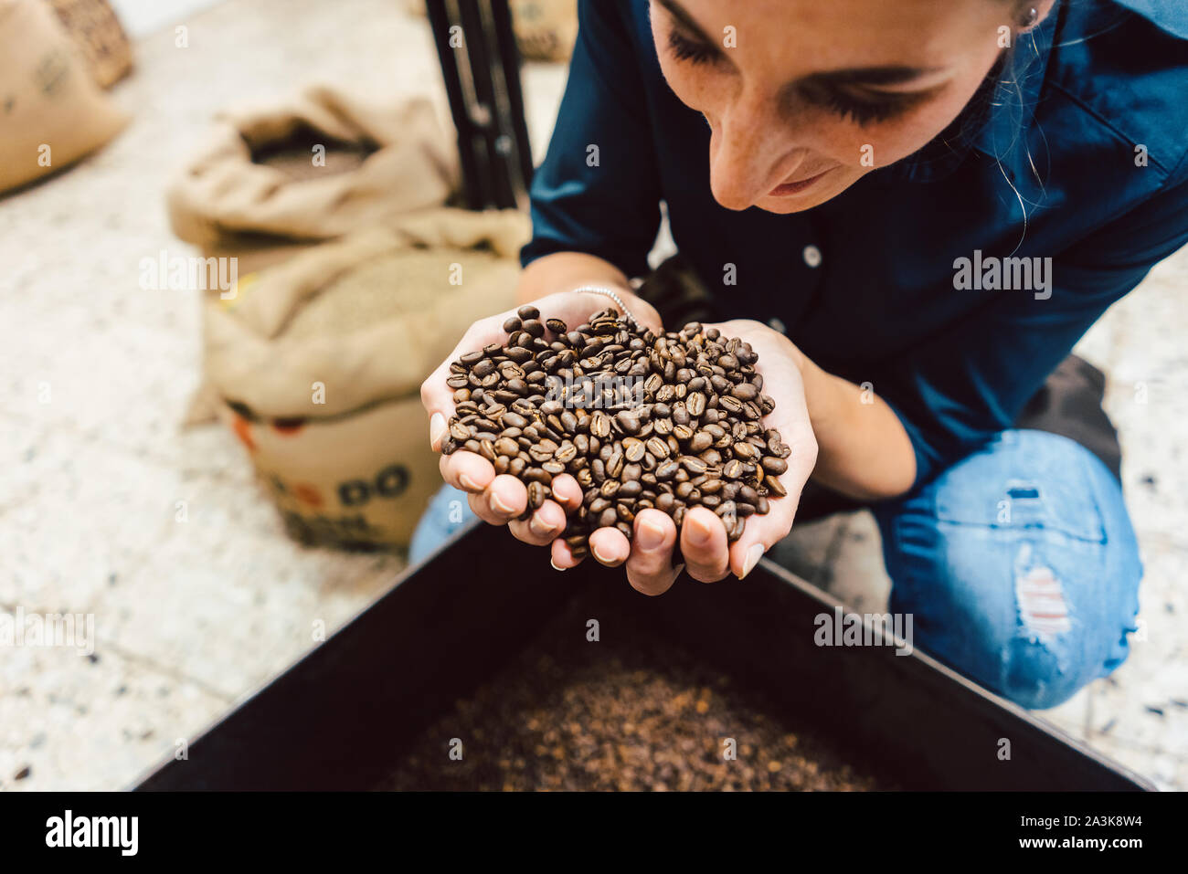 Barista donna test l'aroma del caffè fresco fagioli Foto Stock
