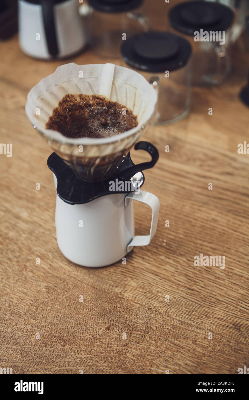 Caffè alternativi. Imbuto con filtro e caffè sulla brocca e bollitore in  metallo Foto stock - Alamy