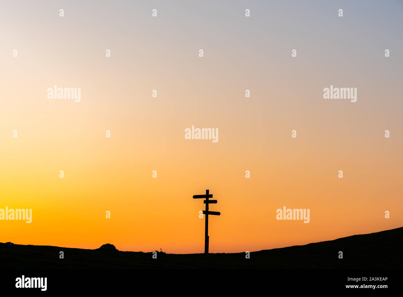 21/8-19, Mugarra, Pais Vasco, Spagna. Un solitario indicazioni del cartello in legno con tre segni in diverse direzioni stagliano contro un bel Cielo di tramonto. Foto Stock