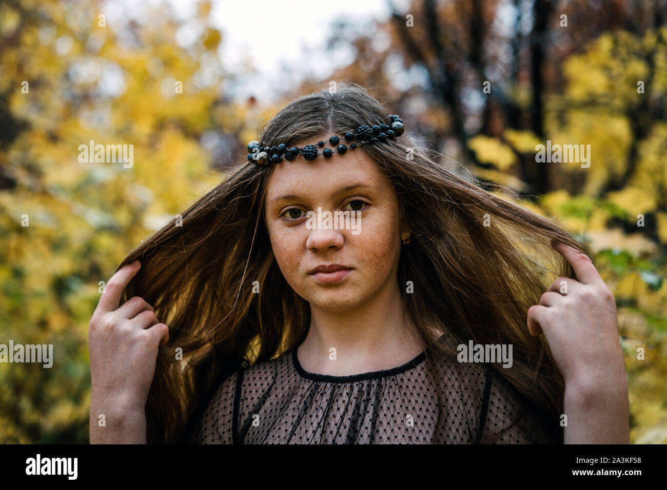 Freckled redhead girl in autunno parco giallo Foto Stock