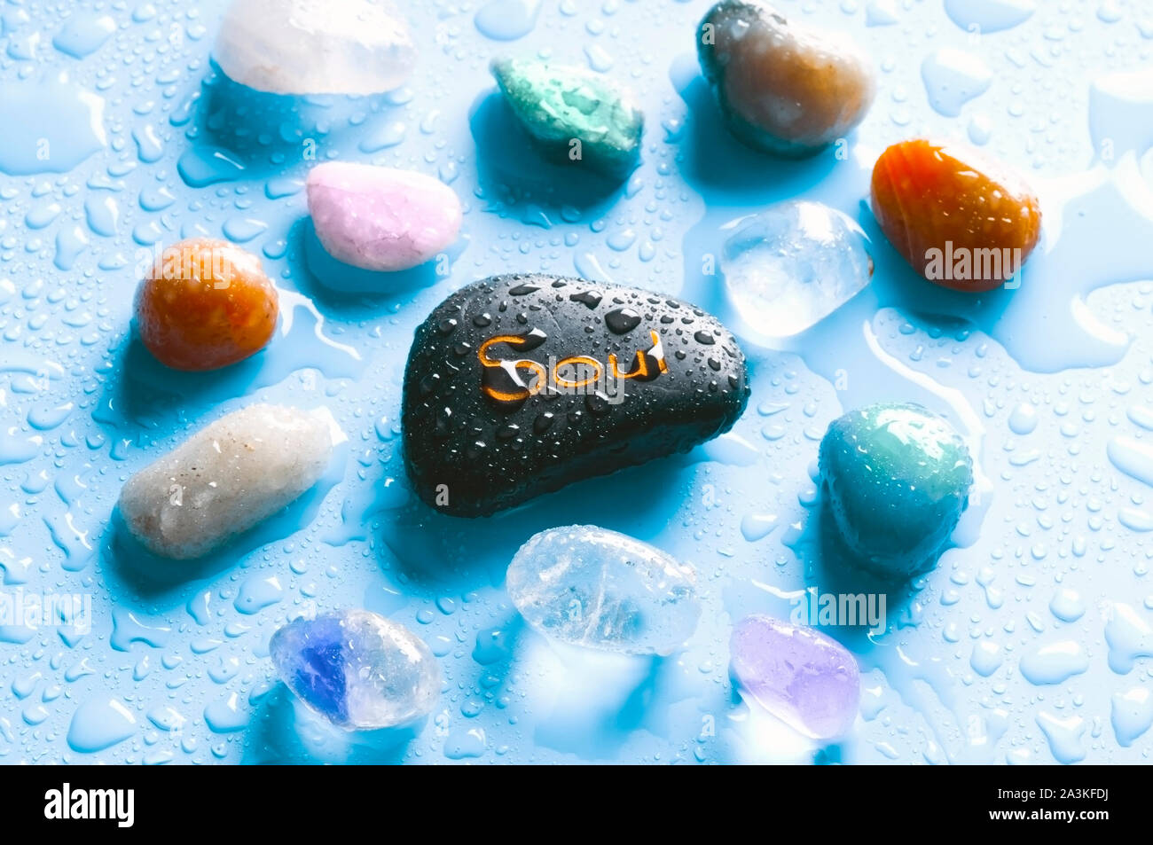 Gemme curative colorate e una pietra con il concetto di benessere e consapevolezza dell'anima di parola Foto Stock