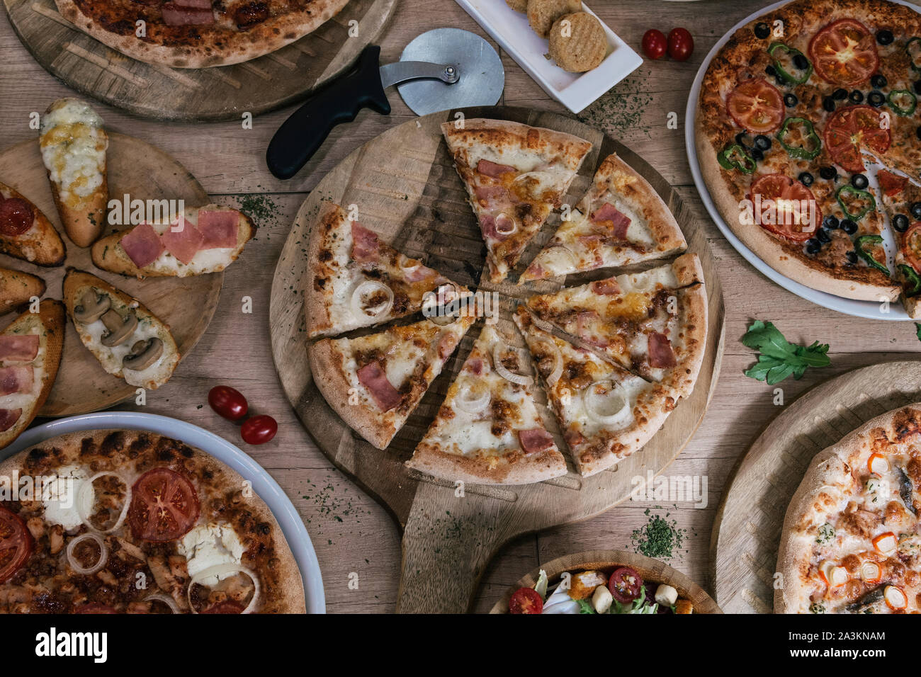 Pizza italiana e pizzeria concetto. Pizza diversi set di menu. Prendere via il cibo con vari ingredienti e croccante di bordo. Cerchi di pizza con carne, m Foto Stock