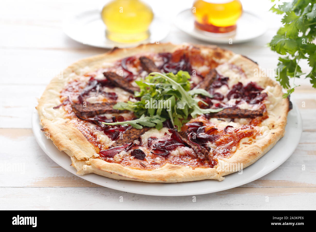 Vegan pizza con salsa di pomodoro e affumicati, tempeh e cipolle rosse. Foto Stock