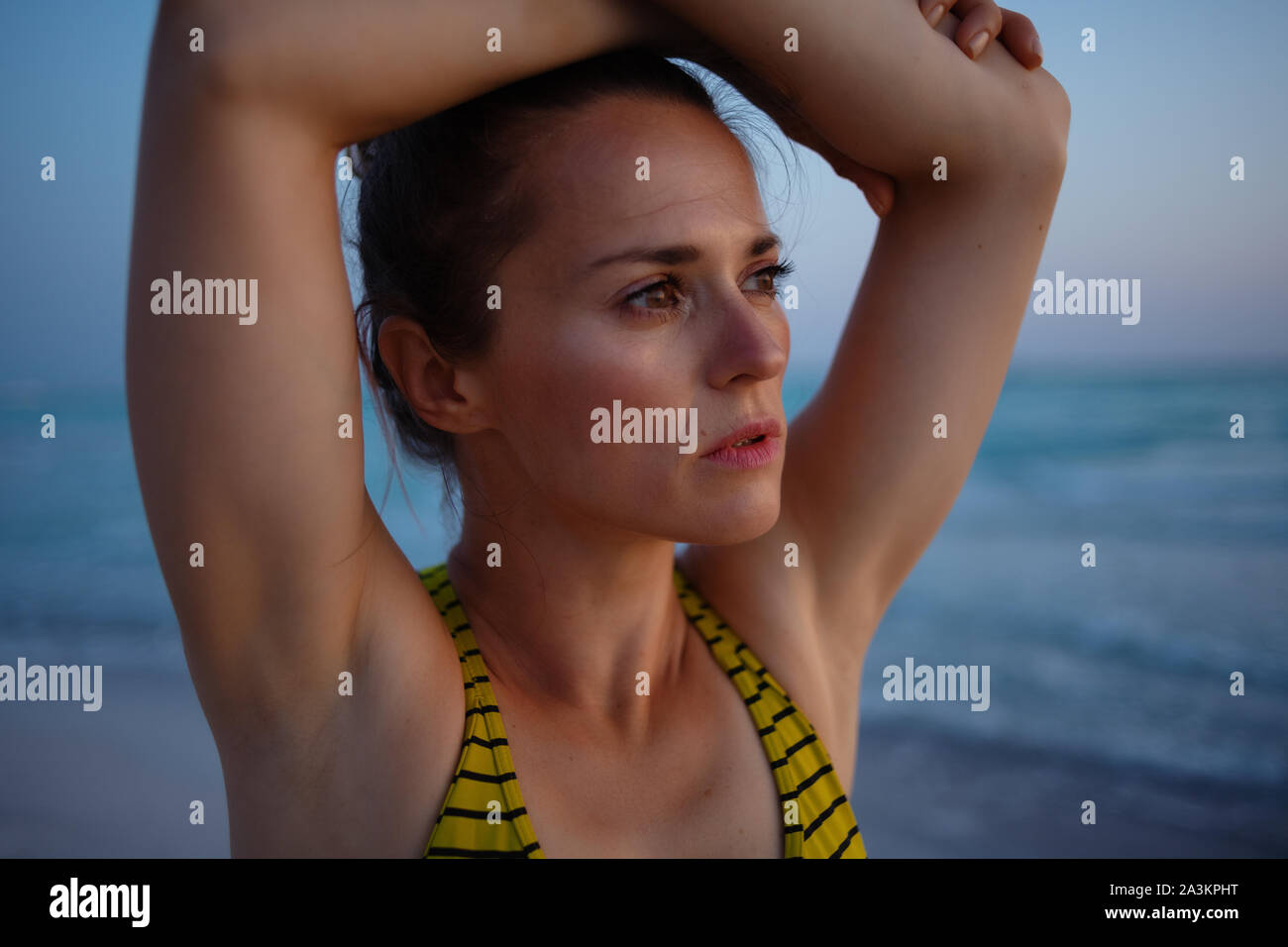 Active sport donna in abiti da fitness in riva al mare in serata rilassante dopo allenamento. Foto Stock