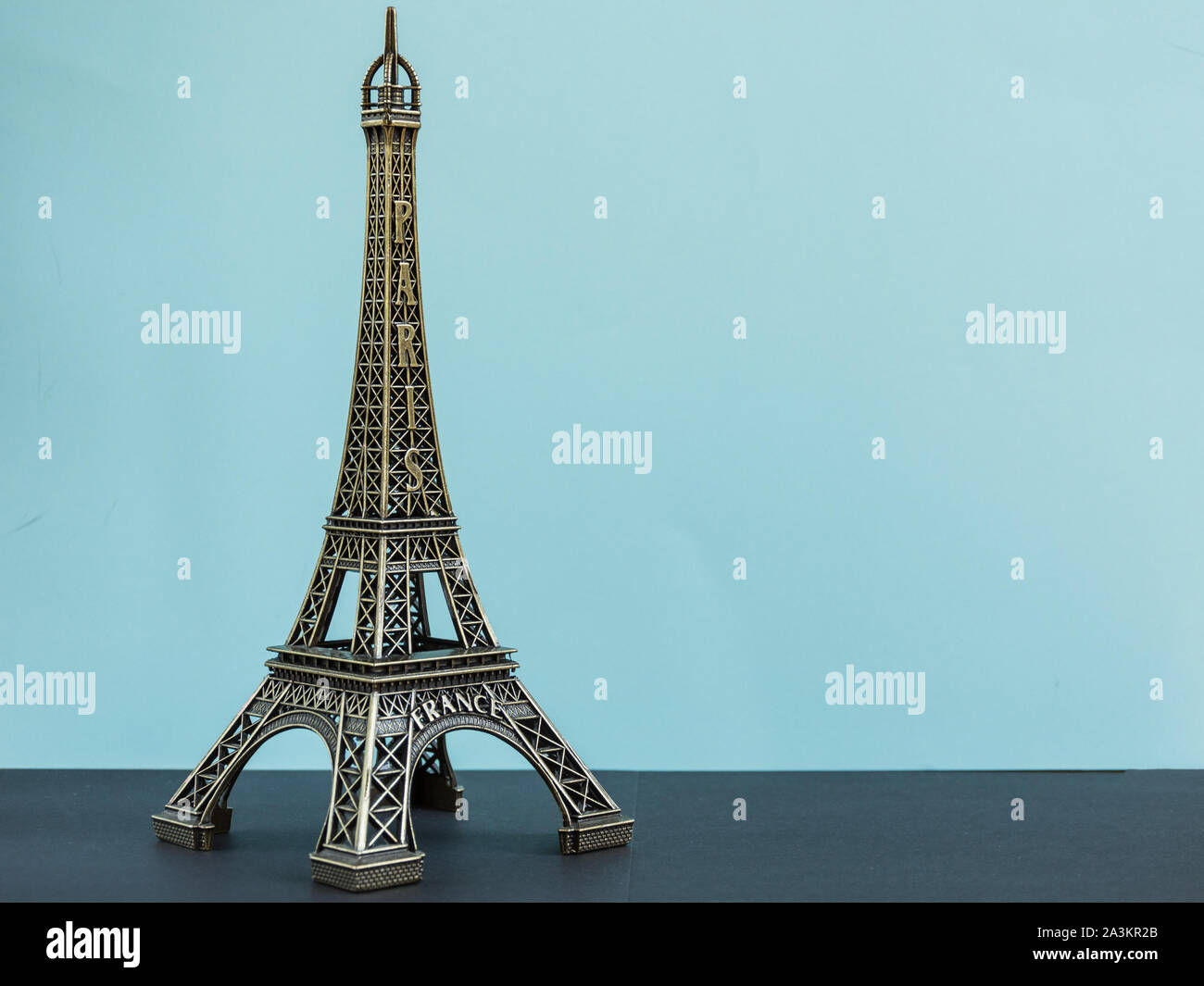Toy torre eiffel sul pastello blu sullo sfondo. Parigi souvenir, simbolo della Francia. Foto Stock