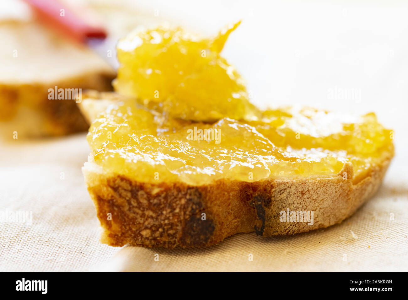 Diffusione di orange marmellata su una fetta di pane Foto Stock