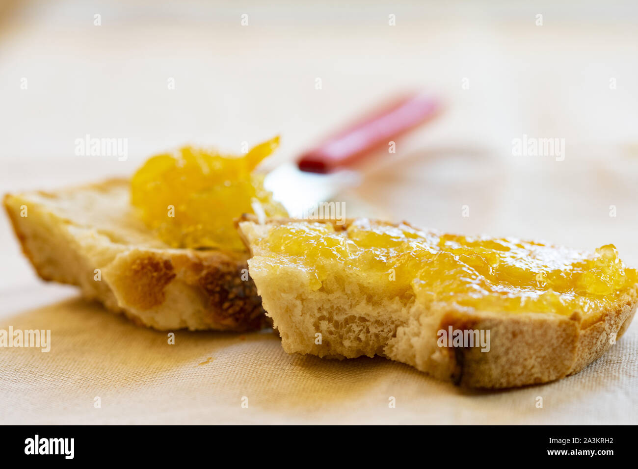 Diffusione di orange marmellata su una fetta di pane Foto Stock