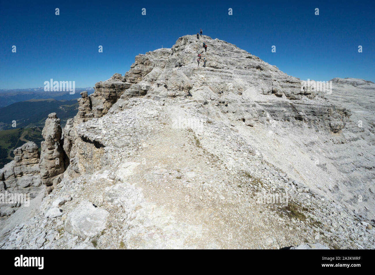 Dolomiti paesaggio di montagna vicino al Passo Sella con molti alpinisti voce al vertice e una pietra cairn in primo piano Foto Stock