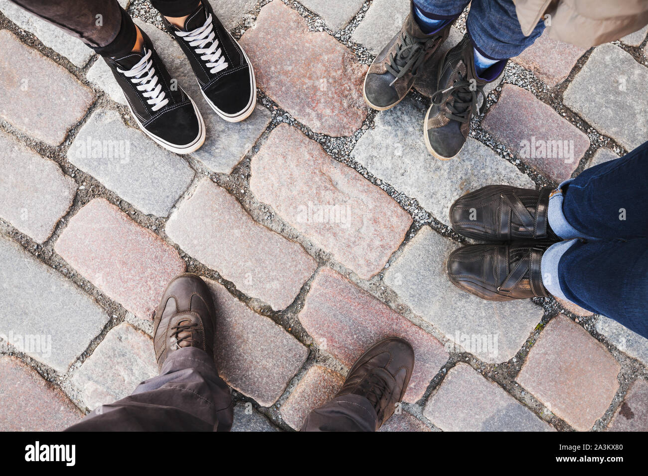 Piedi di una famiglia in piedi insieme su una strada asfaltata, vista dall'alto Foto Stock