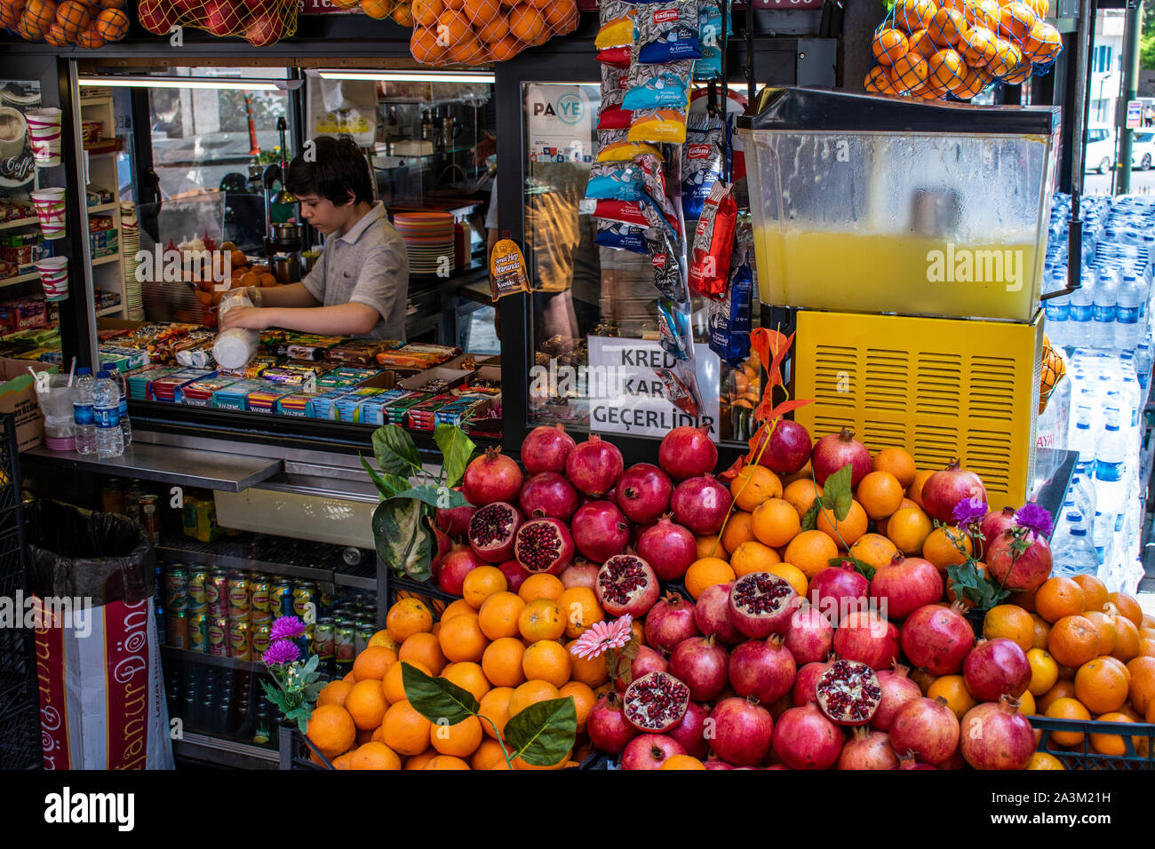 Istanbul, Turchia, Medio Oriente: la vita quotidiana della città, un ragazzo turco lavora in un chiosco dove vendono arancio e melograno centrifughe Foto Stock