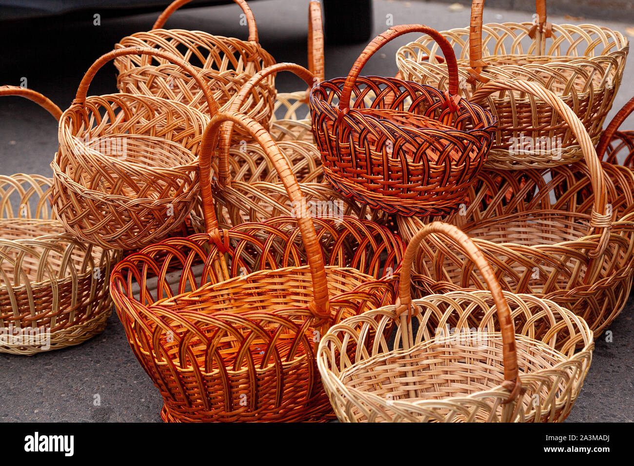 Gruppo di svuotare cestini di vimini per la vendita in un luogo di mercato. Cumulo di cesti di vimini color marrone scuro rotondo ovale vendita presso il mercato degli agricoltori Foto Stock