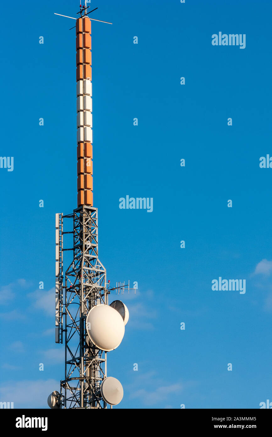 Telecommunications Tower, antenna e parabola satellitare con cielo blu su sfondo. Foto Stock