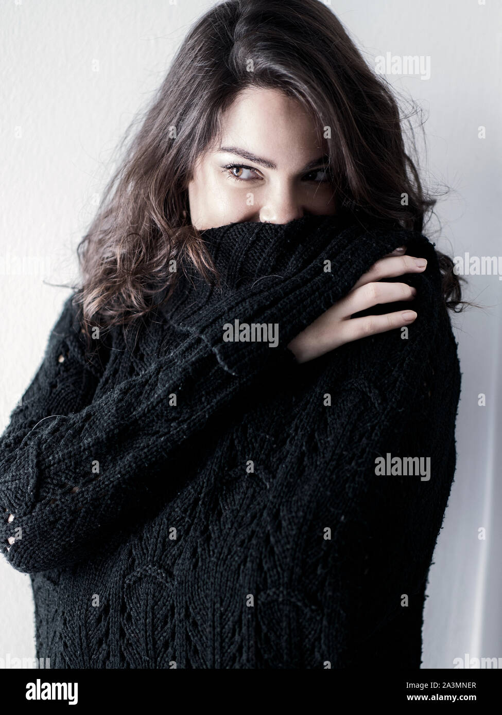 Piuttosto giovane donna che indossa un maglione nero Foto Stock