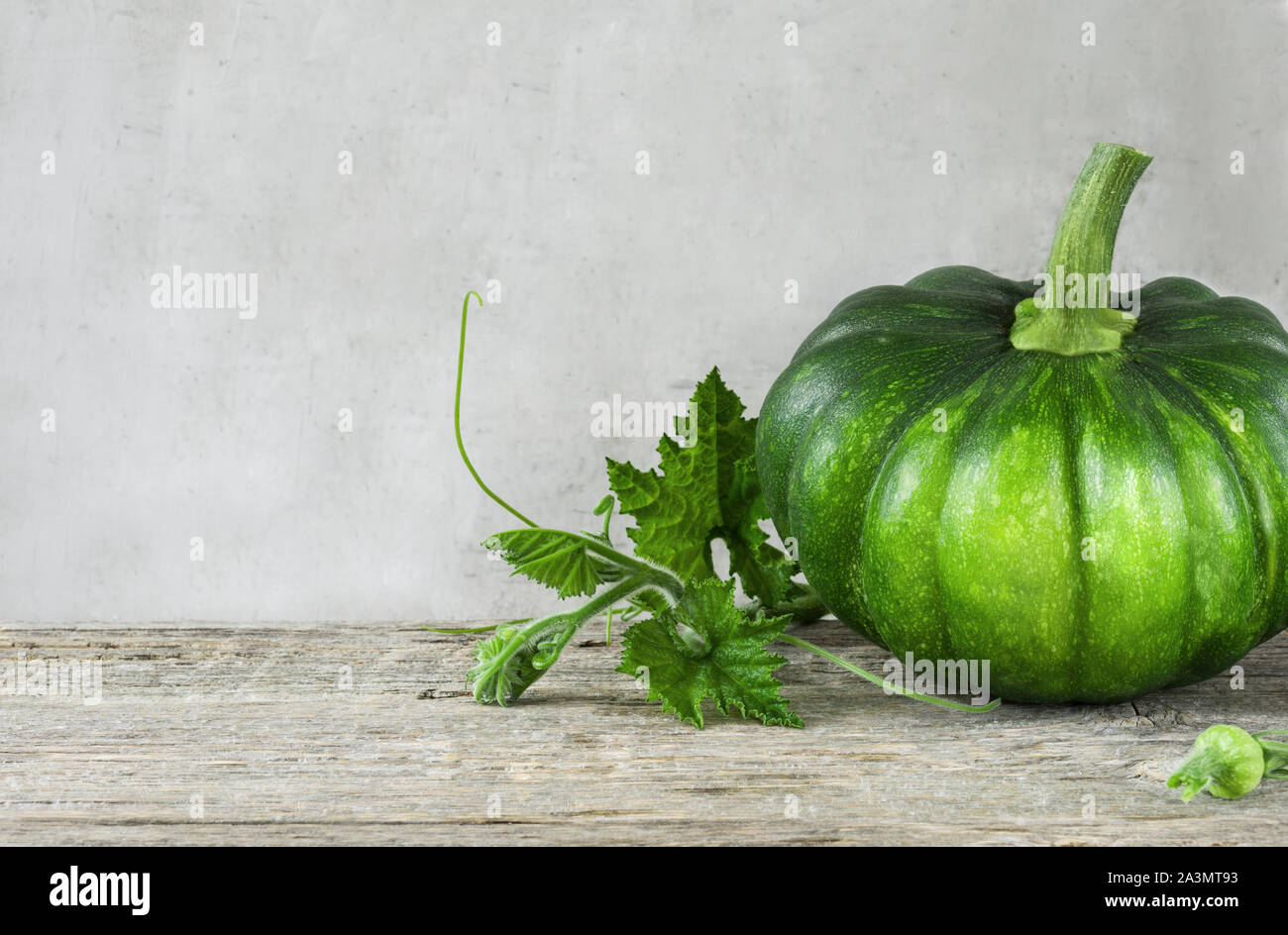 Homegrown zucca organico con il gambo e le foglie di sfondo di legno vista frontale.Sfondo con spazio copia,orizzontale. Foto Stock