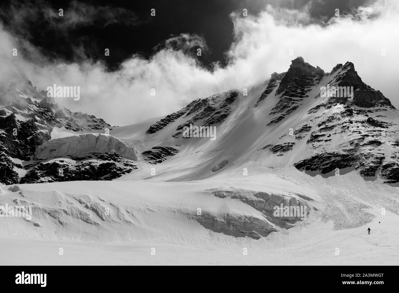 Uomo che discende il Gran Paradiso glacier durante l'inverno il nord-ovest. Il peack è il più alto monte interamente in territorio italiano. Foto Stock