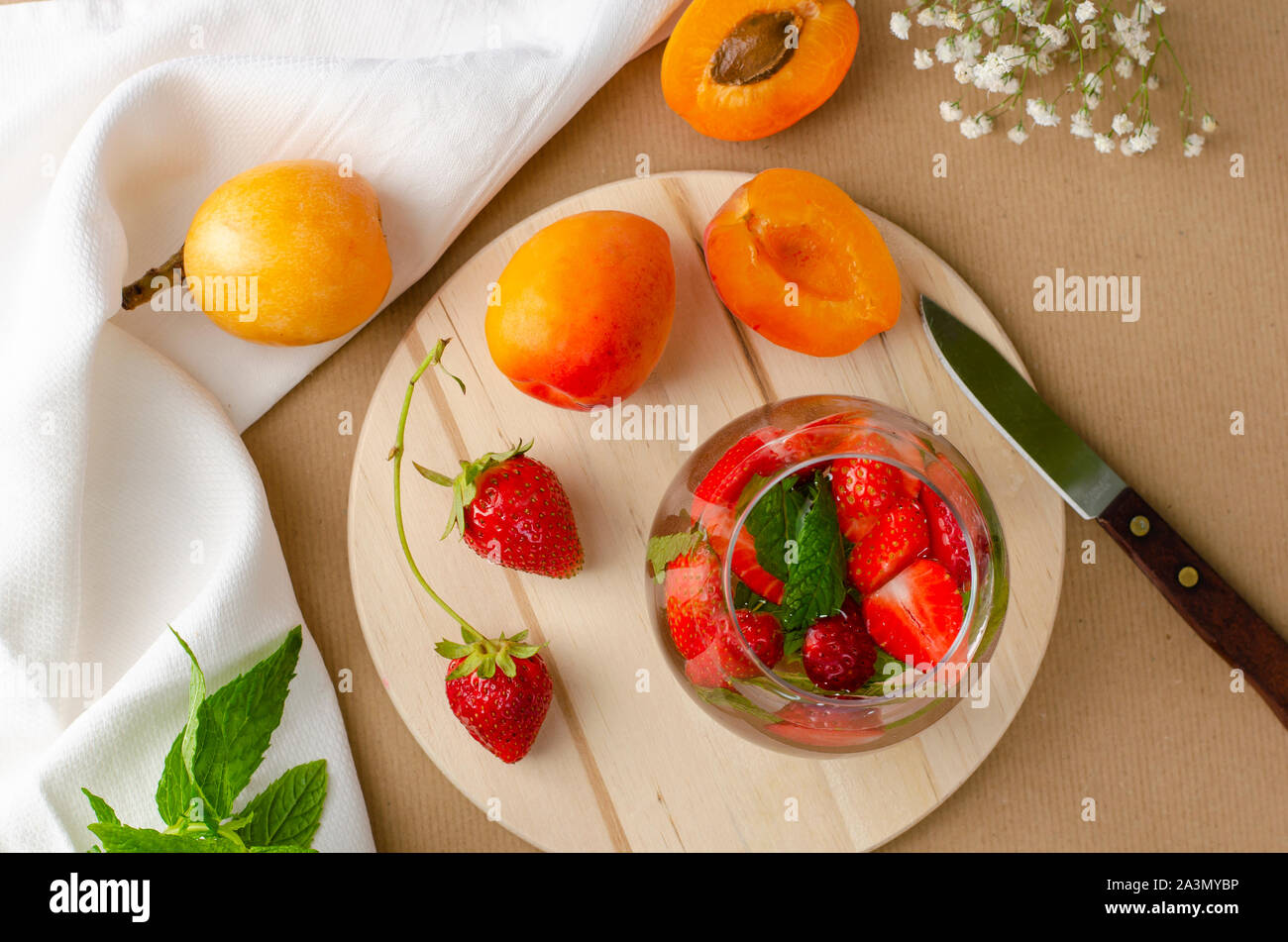 Punzone di fragole fatta in casa , cocktail fresche Albicocche e Nespole del Giappone sullo sfondo. Un drink rinfrescante di concetto. Foto Stock